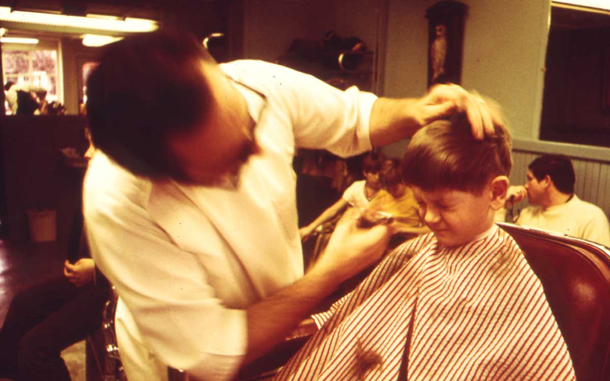 Barber giving haircut to a child
