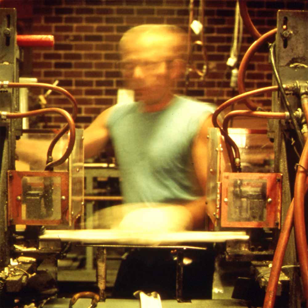 Blurry image of a factory worker as he quickly moves between tasks