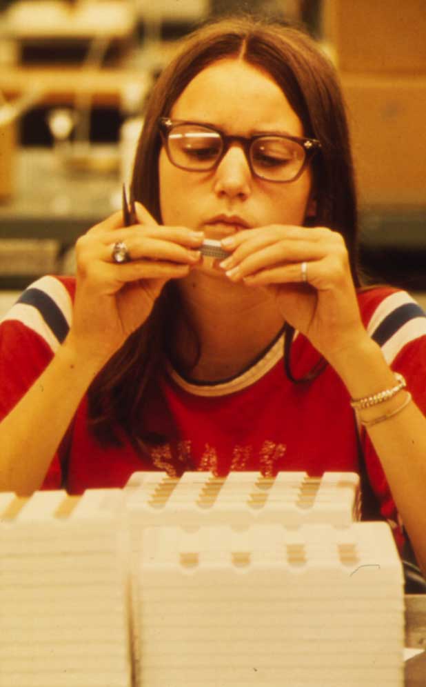 Woman quality-checking mechanical parts